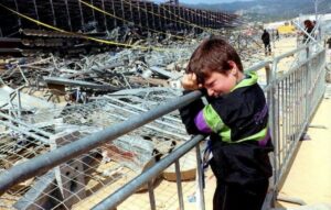 Un enfant regarde en pleurant la tribune effondrée du stade de Furiani