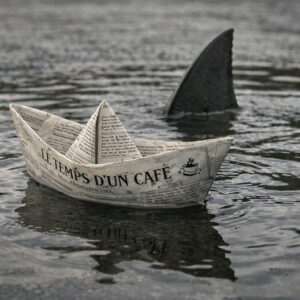 Bateau confectionné avec le papier journal "Le temps d'un café" et un requin rôdant autour