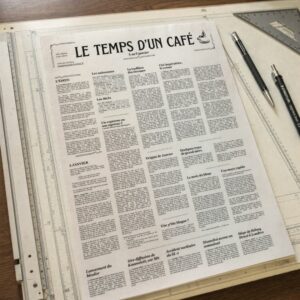 Journal "Le temps d'un café" posé sur une table à dessin